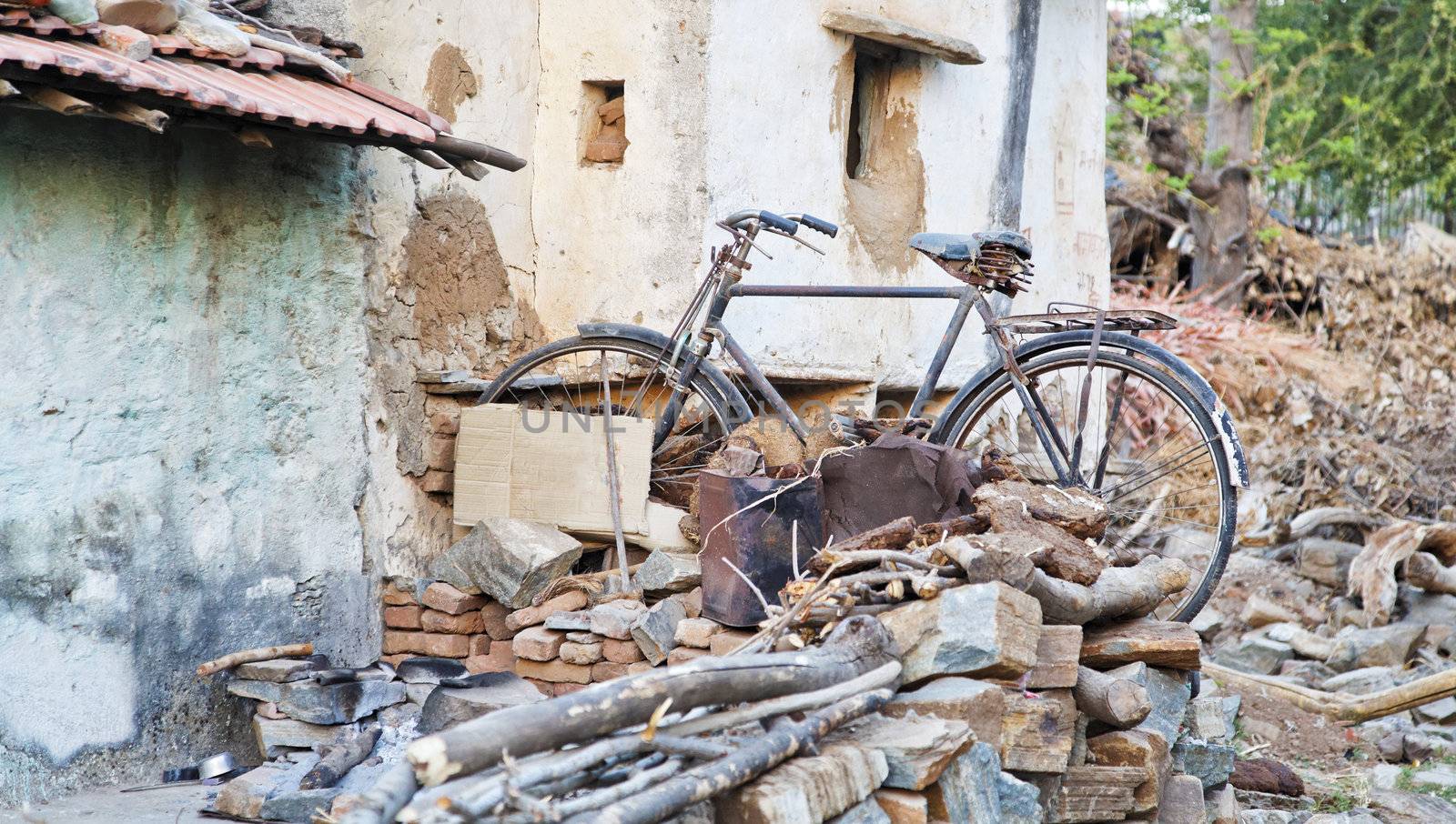 Rajasthan India, peasant dwellings back yard with family transport amongst the household waste