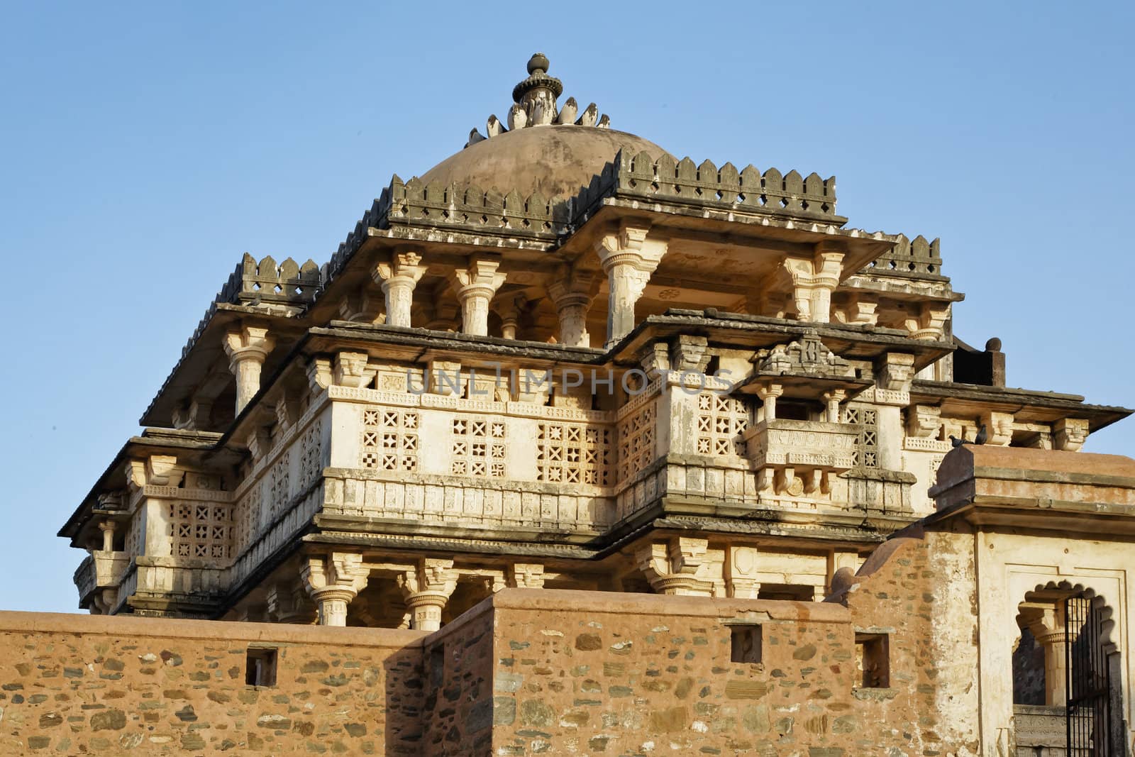 Hindu temple showing signs of aging with the fortification walls of Kumbhalghar Fort, Rajasthan, India, detailing keeping in line of architecture of the palace