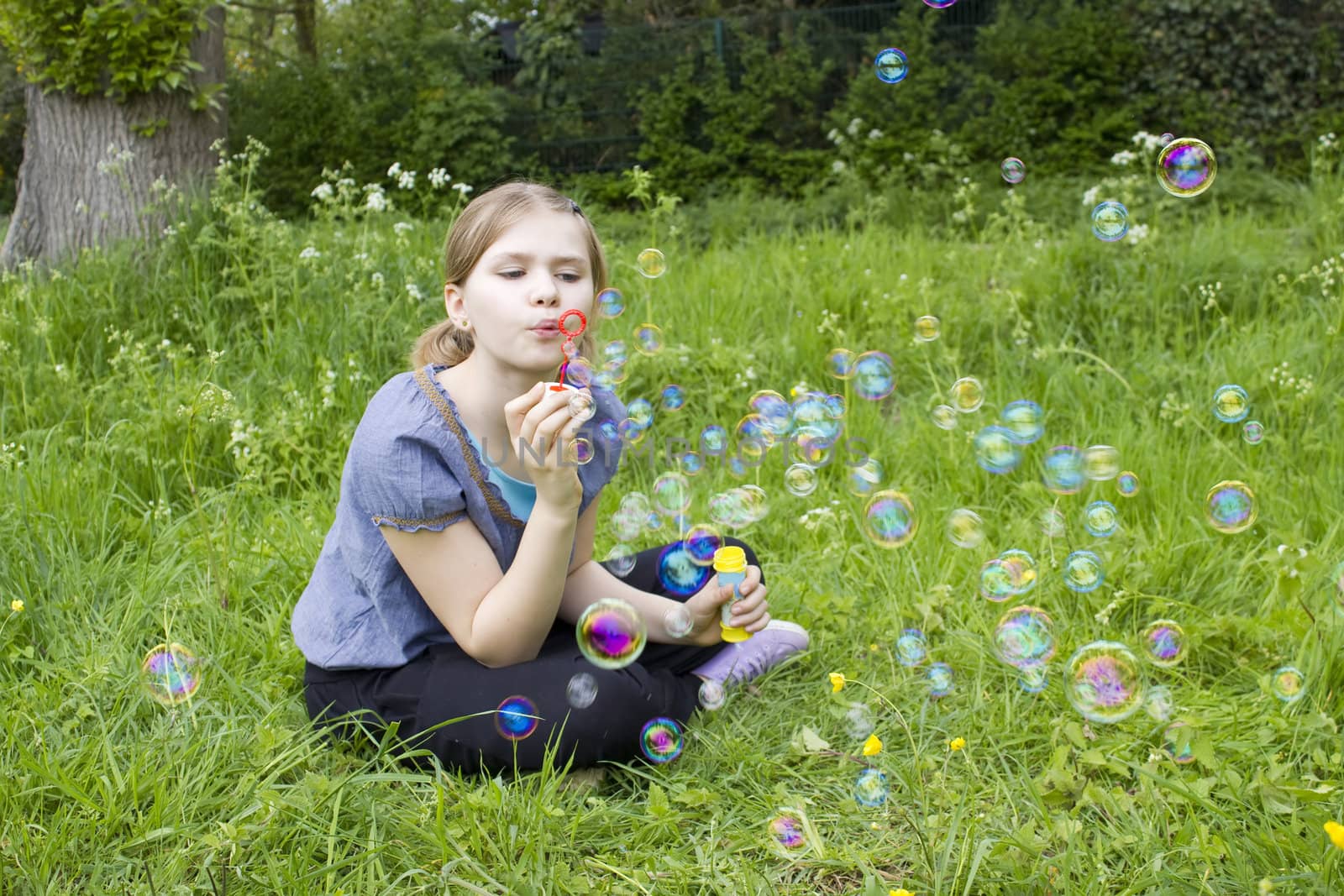 Little girl blowing soap bubbles by miradrozdowski