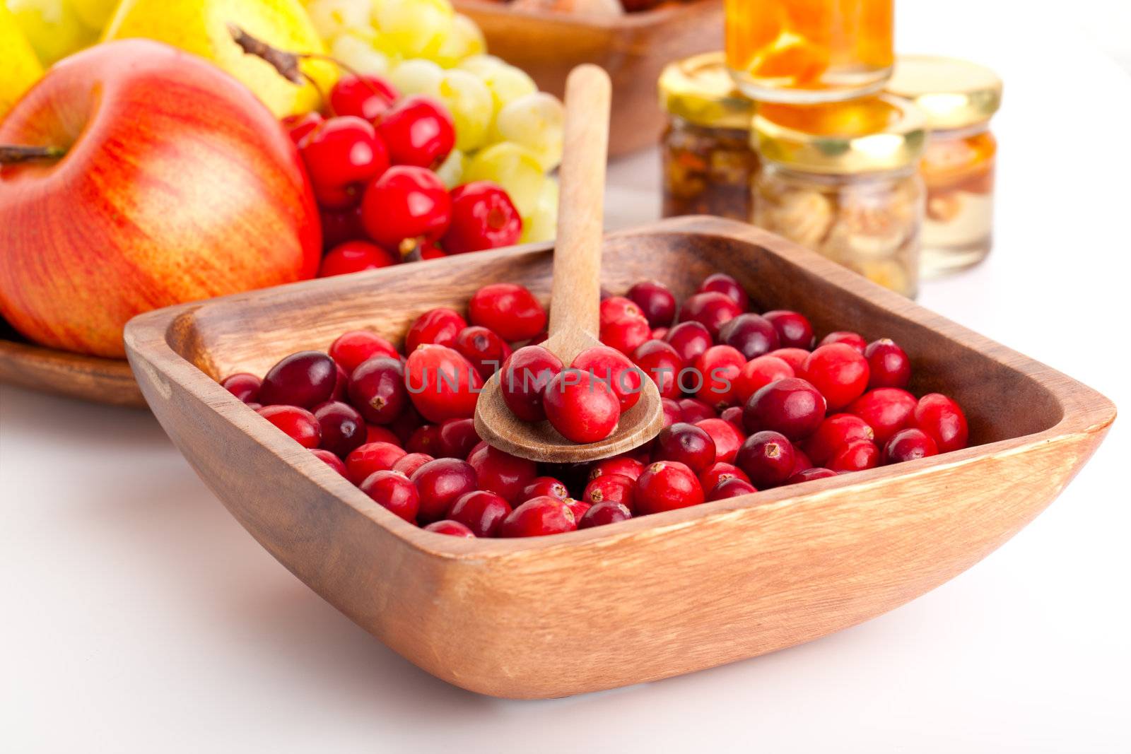 Fresh red cranberries in the wooden bowl with spoon
