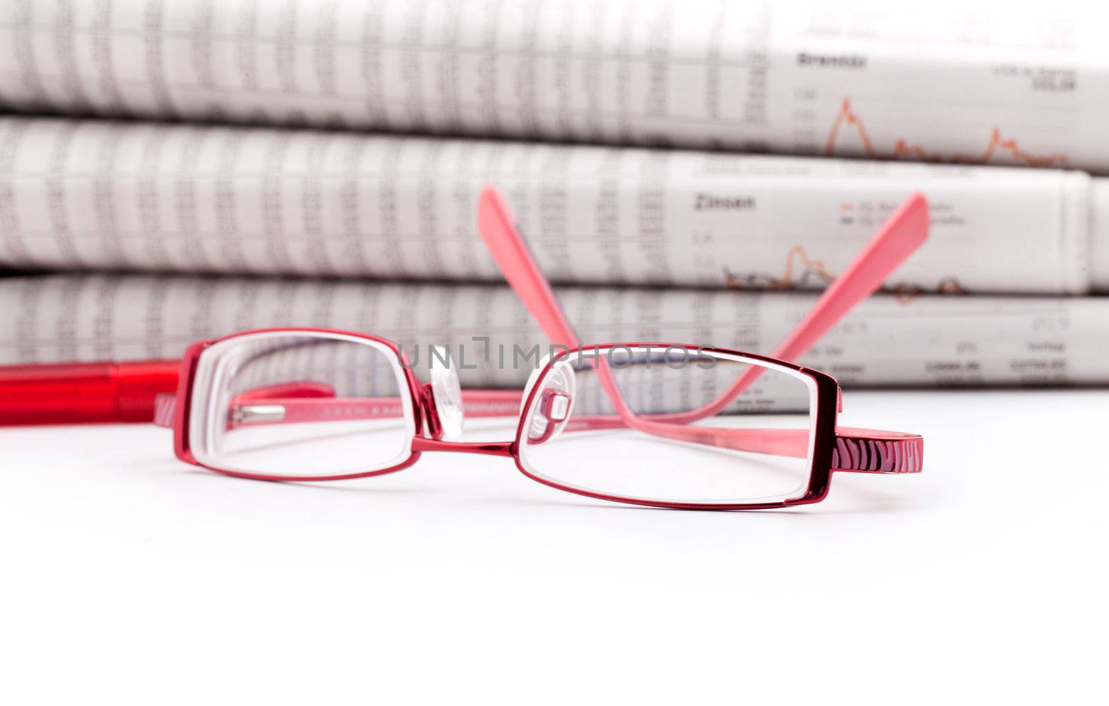 reading glasses lie before a big newspaper pile by motorolka