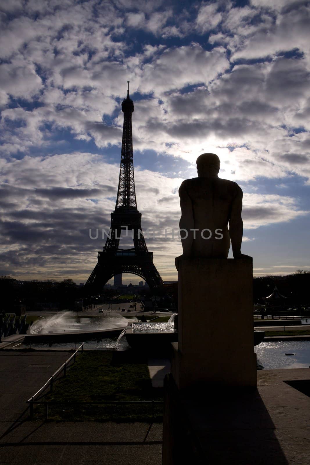Backlit silhouette of Eiffel Tower and statue on Trocadero in Paris