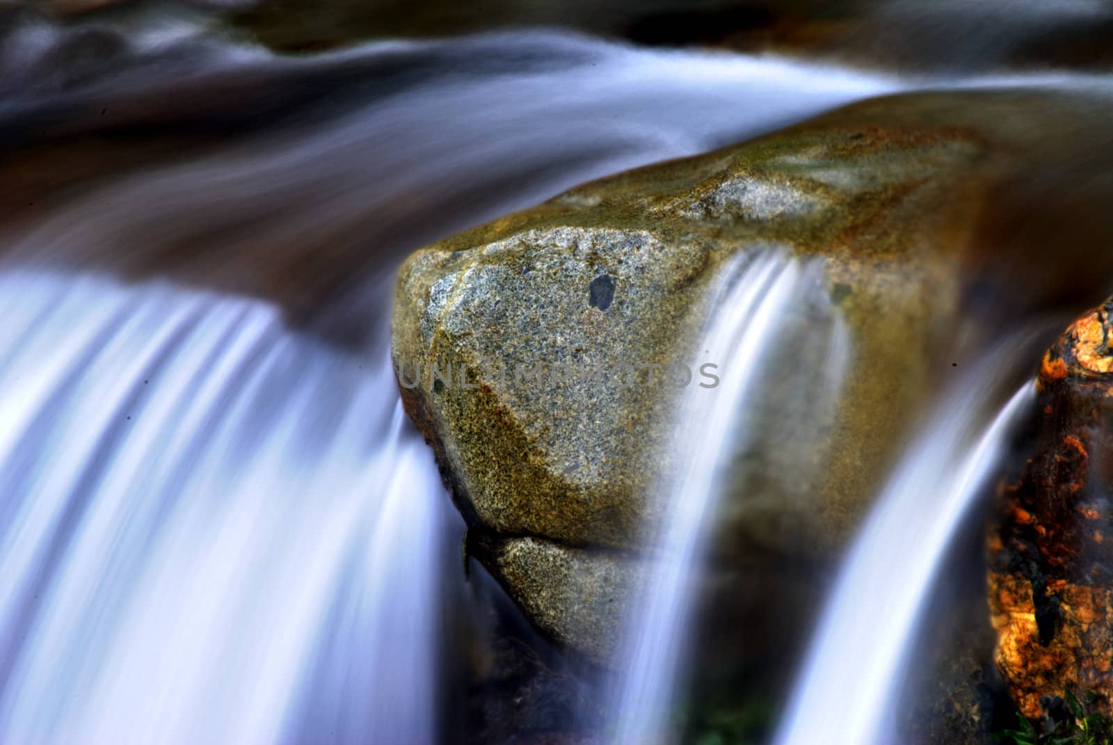 A rock shaped like a turtle on the edge of a waterfall