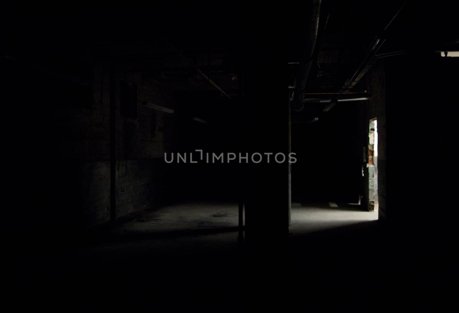 Dark empty warehouse / commercial space with shaft of light