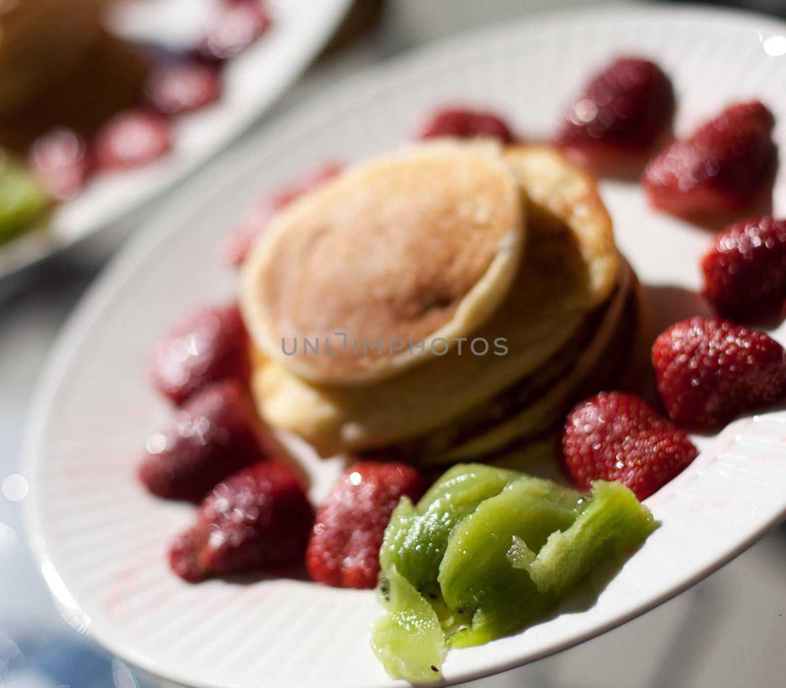 Pancakes with strawberries and kiwis prepared for breakfast