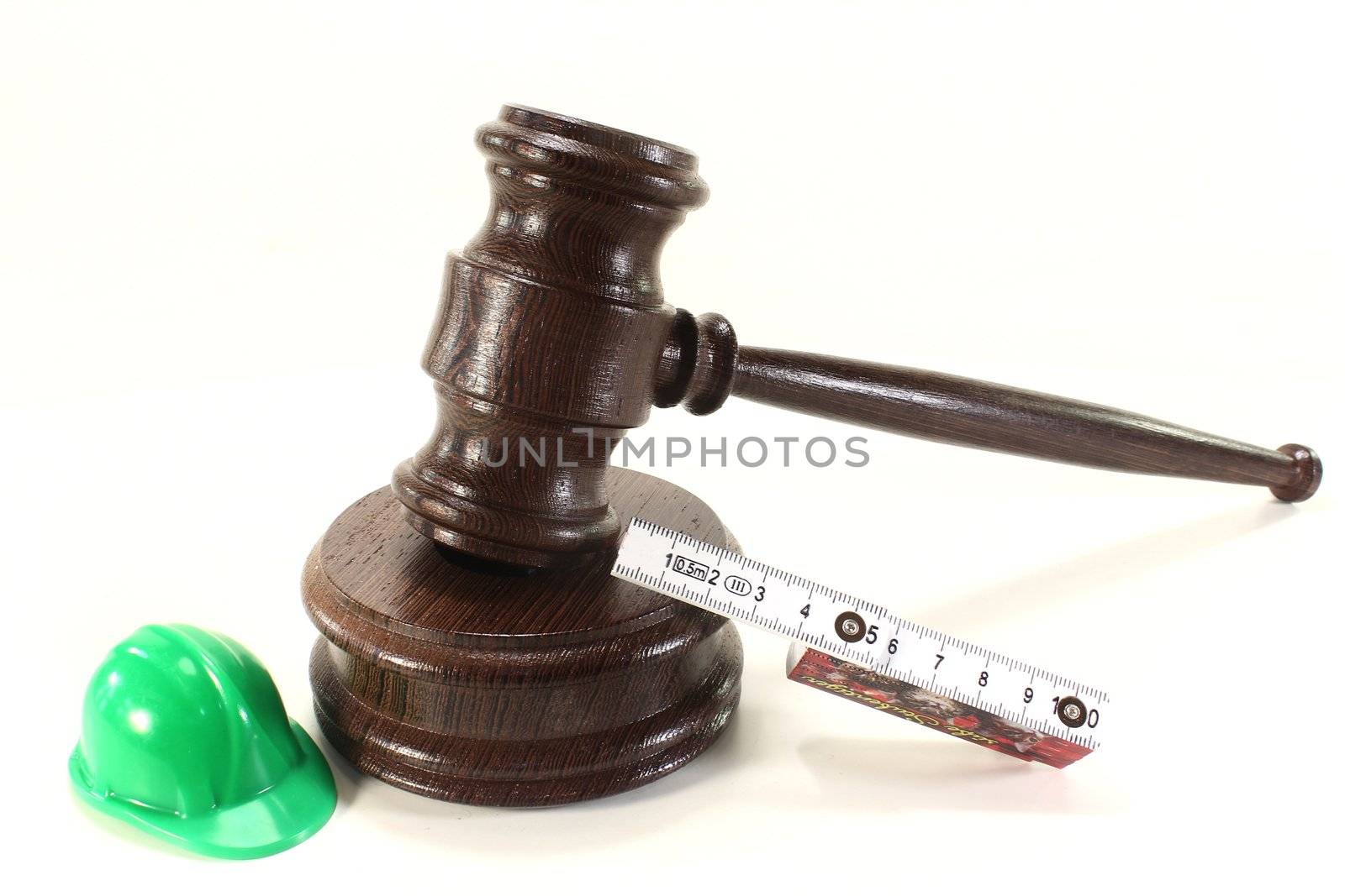 judges gavel with building-site helmet and double meter stick on a light background