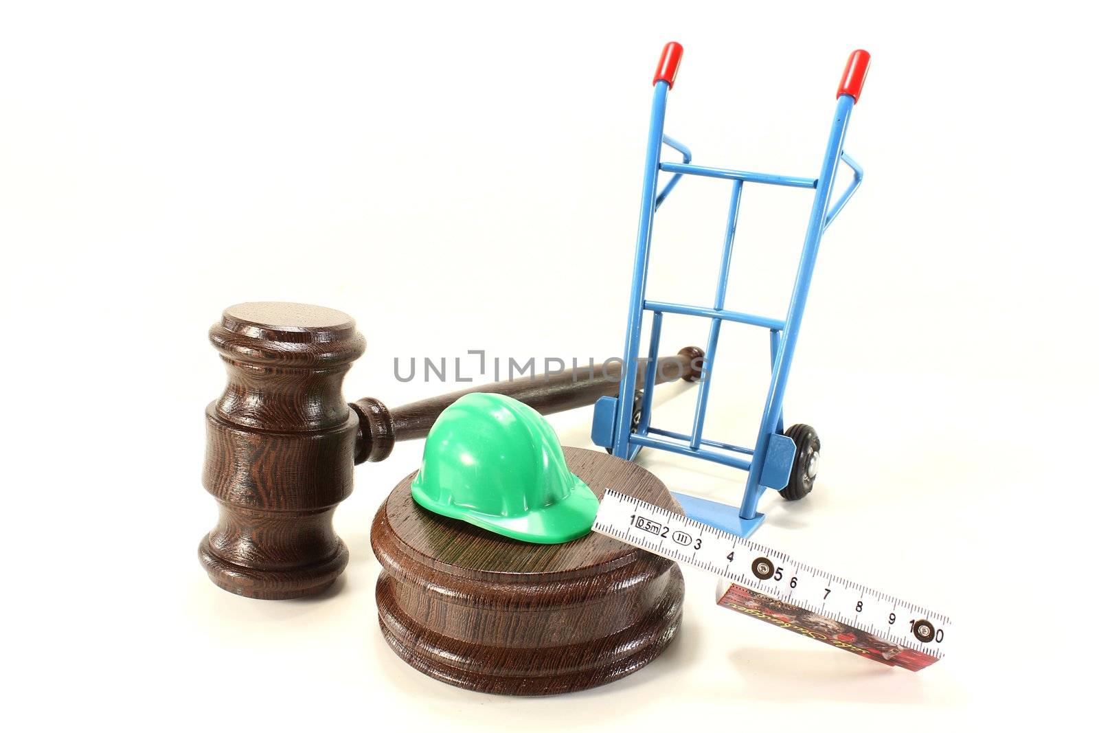 judges gavel with building-site helmet and double meter stick on a light background