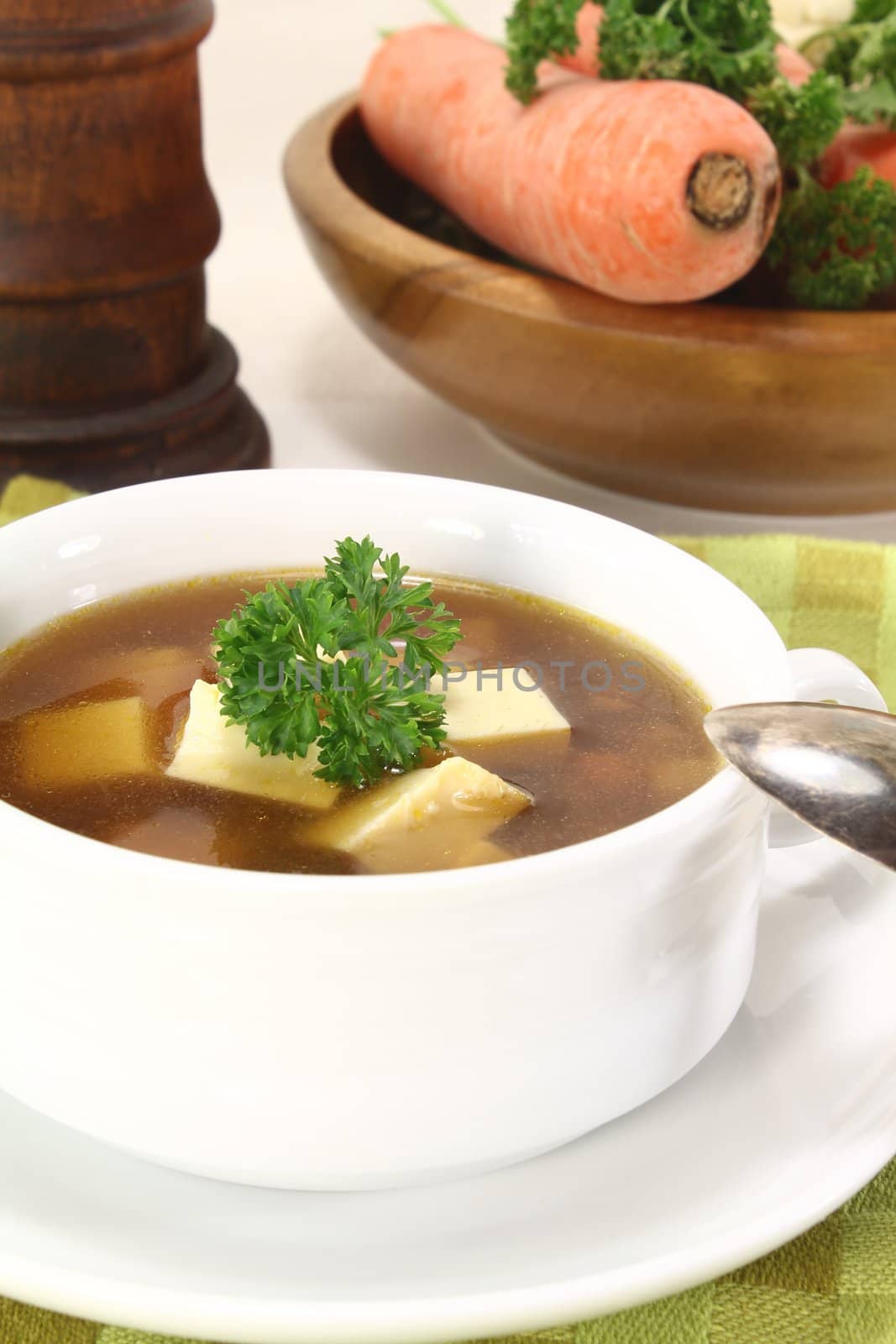 Beef consomme with fresh soup vegetables, egg and parsley