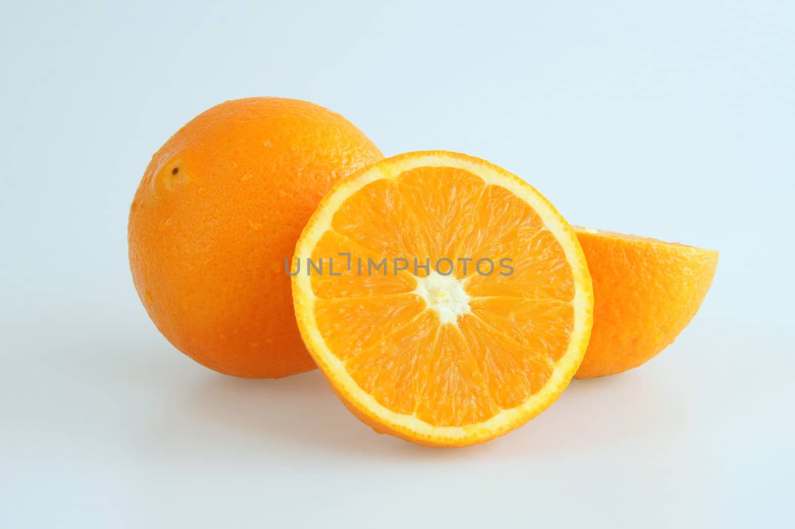 Image of two isolated oranges, one of them is sliced in half