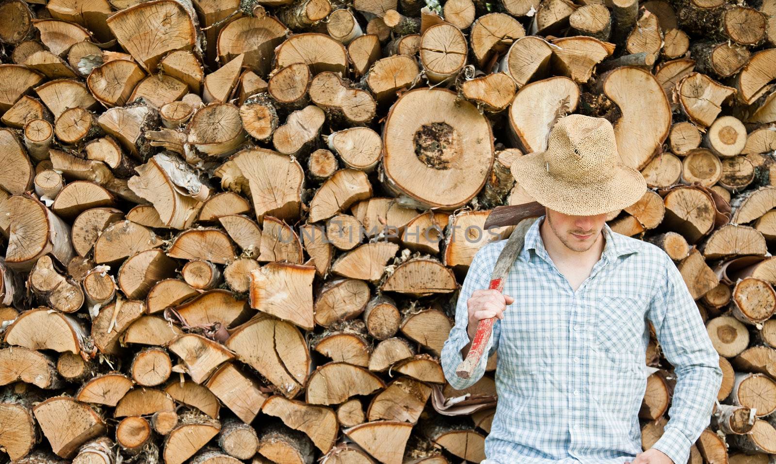 Woodcutter with straw hat on a background of wood by aetb