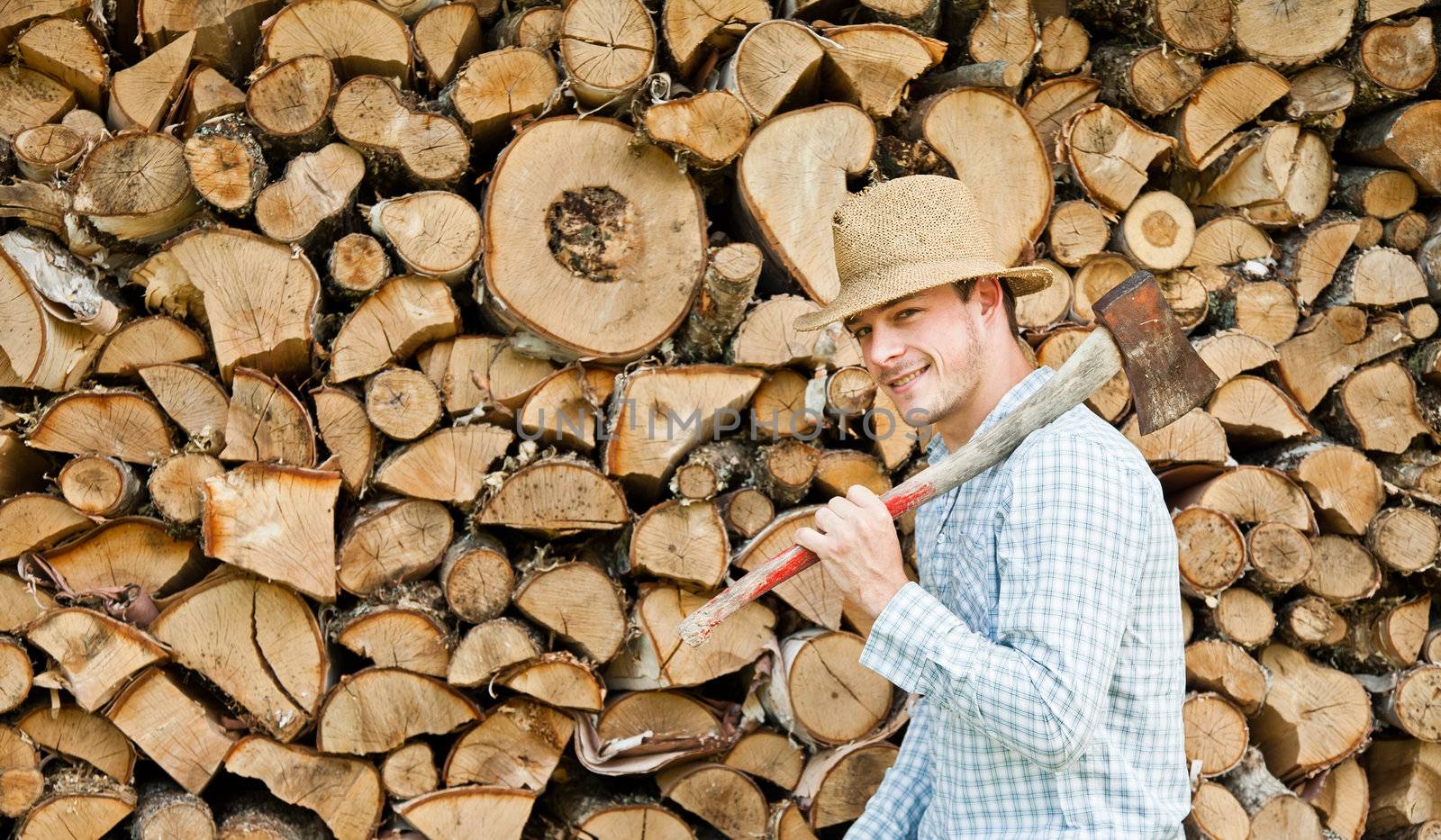 Woodcutter with straw hat on a background of wood by aetb