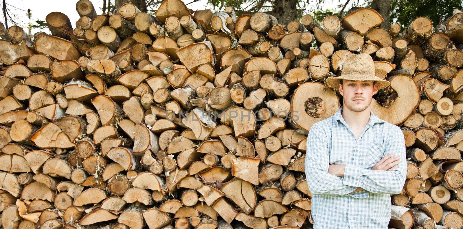 Woodcutter with straw hat on a background of wood - proud
