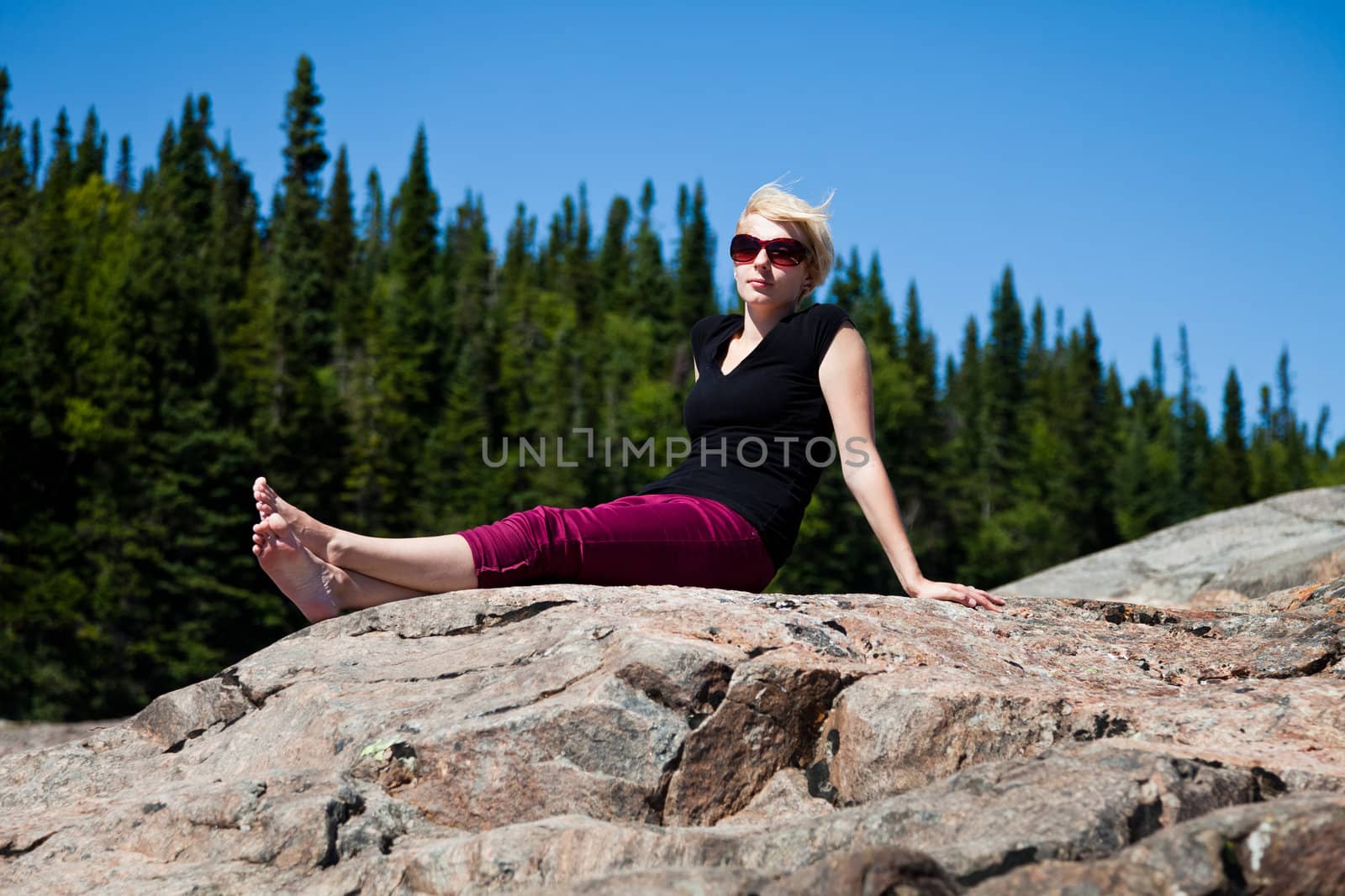 Young girl on a rock in the middle of the nature.