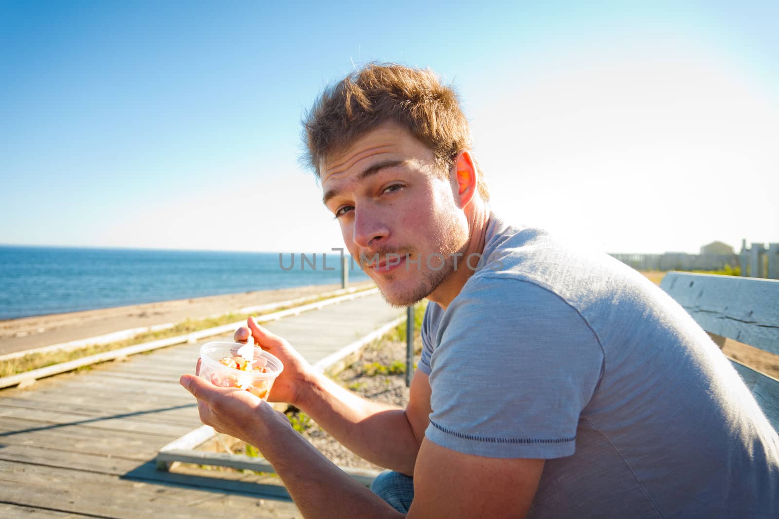 Young man eating seafood on the beach