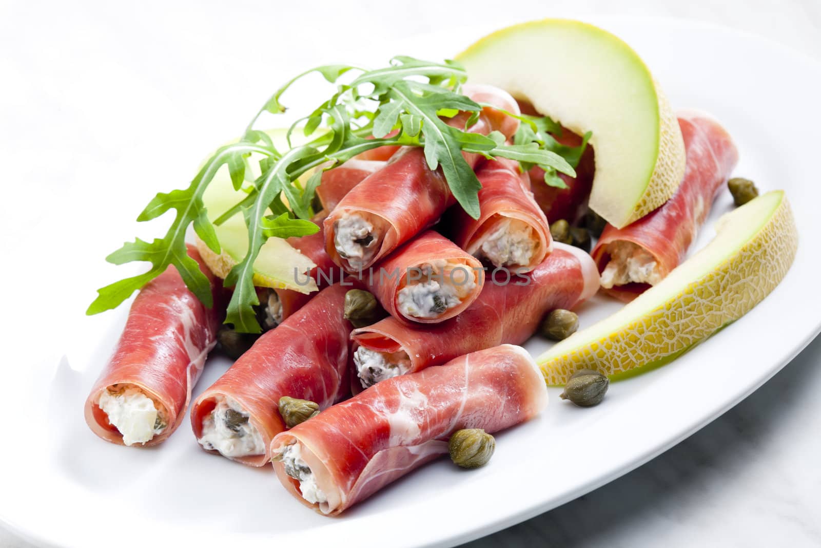 Parma ham rolls filled with cream cheese, Galia melon and capers by phbcz