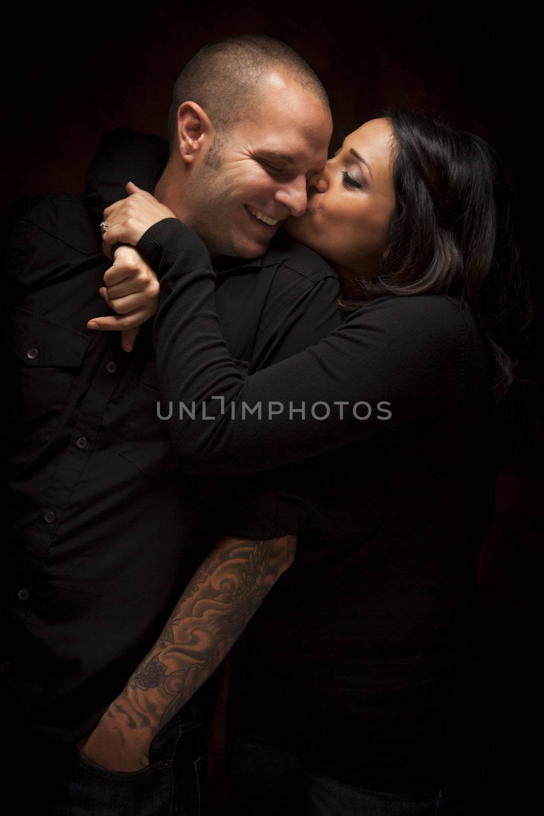 Happy Mixed Race Couple Flirting with Each Other Portrait Against A Black Background.