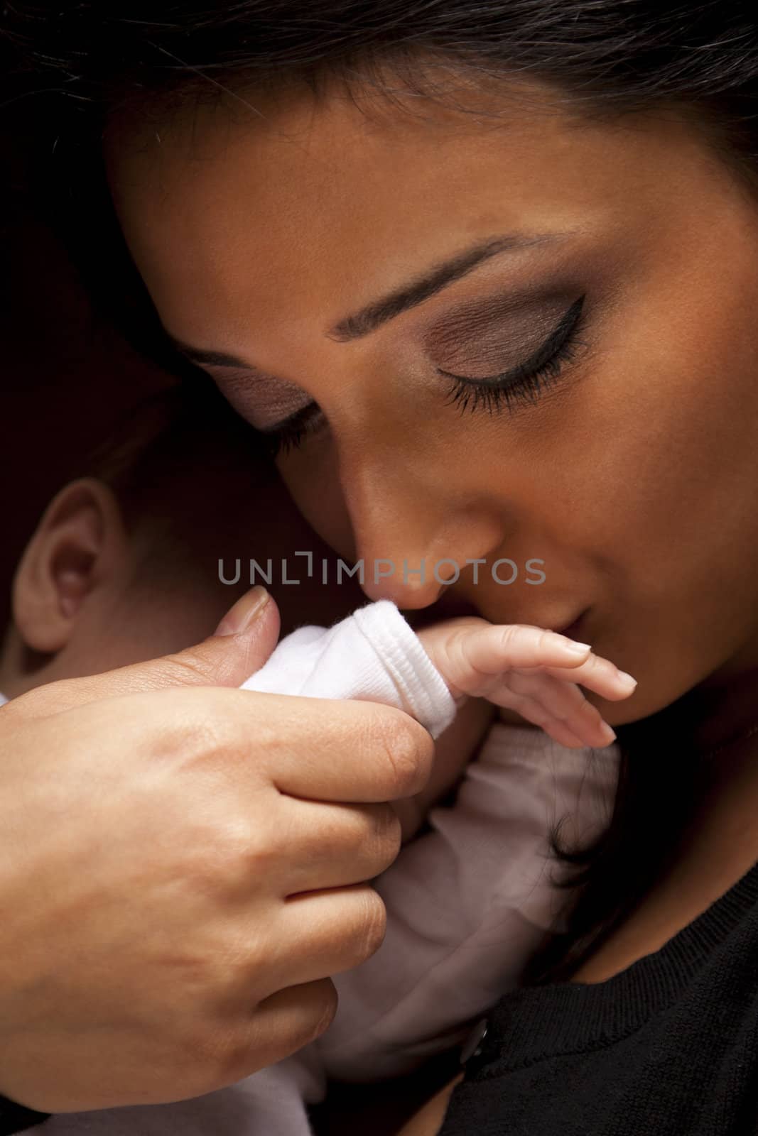 Ethnic Woman Kisses Her Newborn Baby Hand by Feverpitched