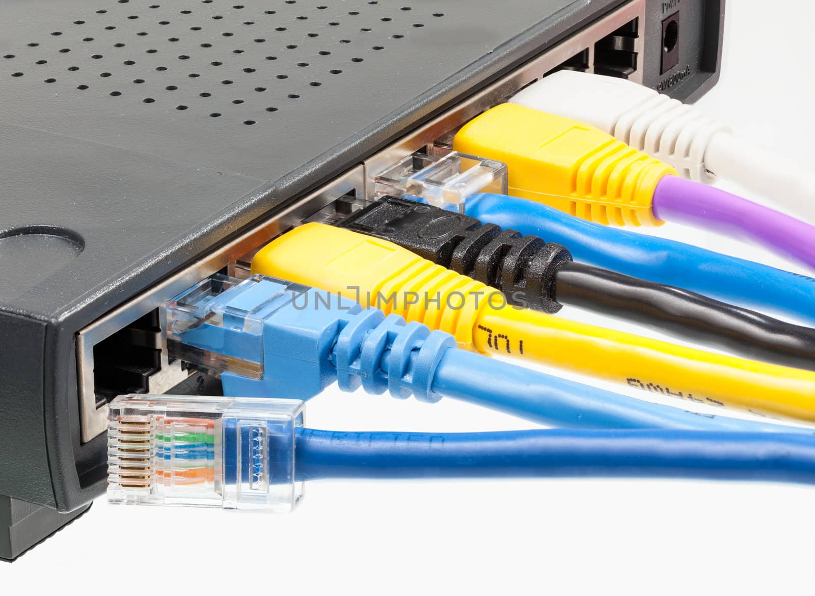 Macro shot of plugs on cat5e cables of many colors isolated against white background plugged into router