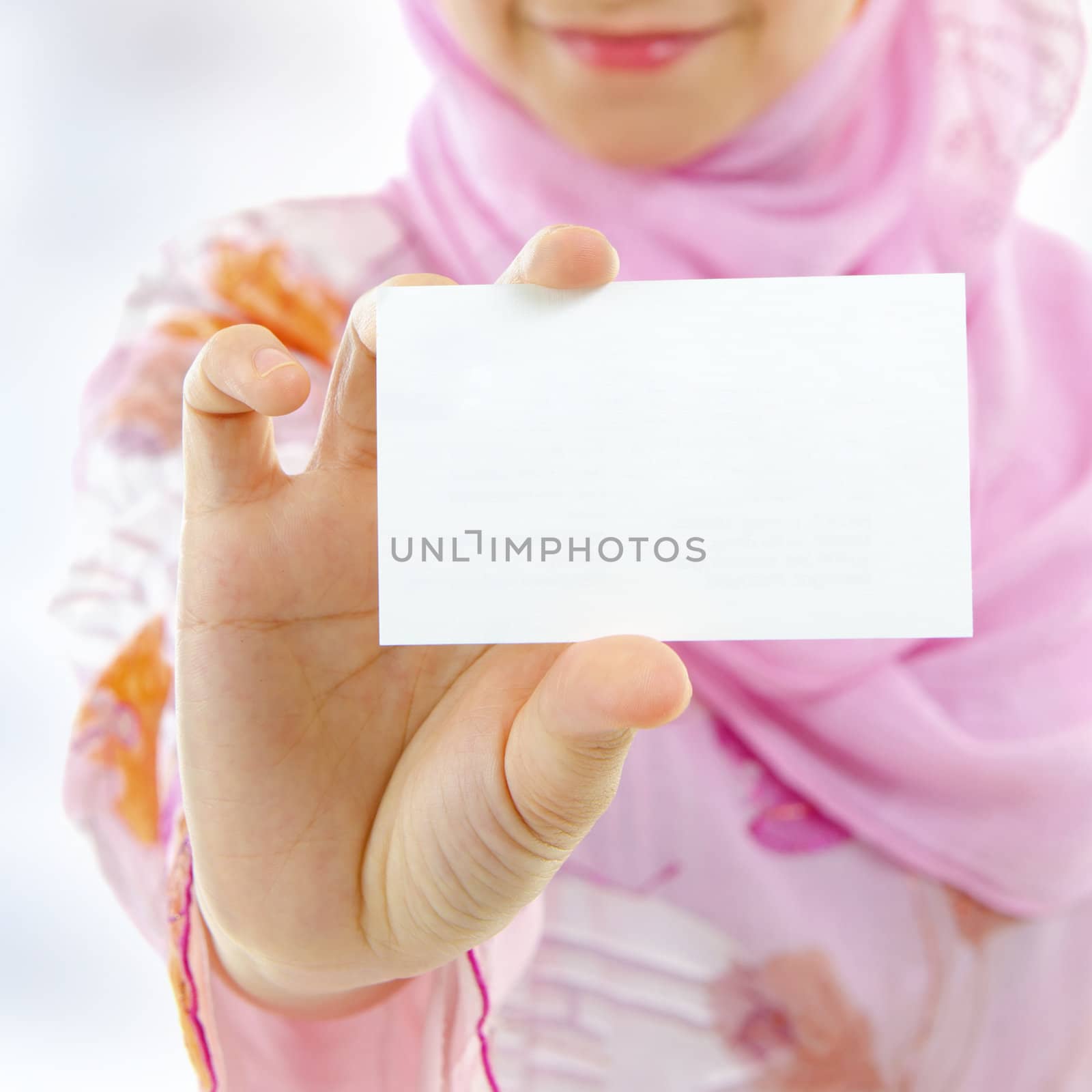 Muslim female holding business card, focus on hand