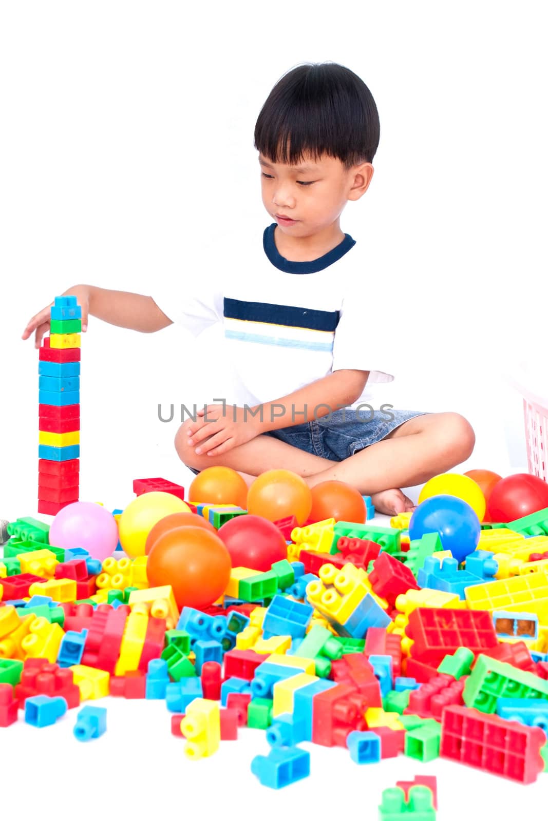 Little boy playing with toy on white background