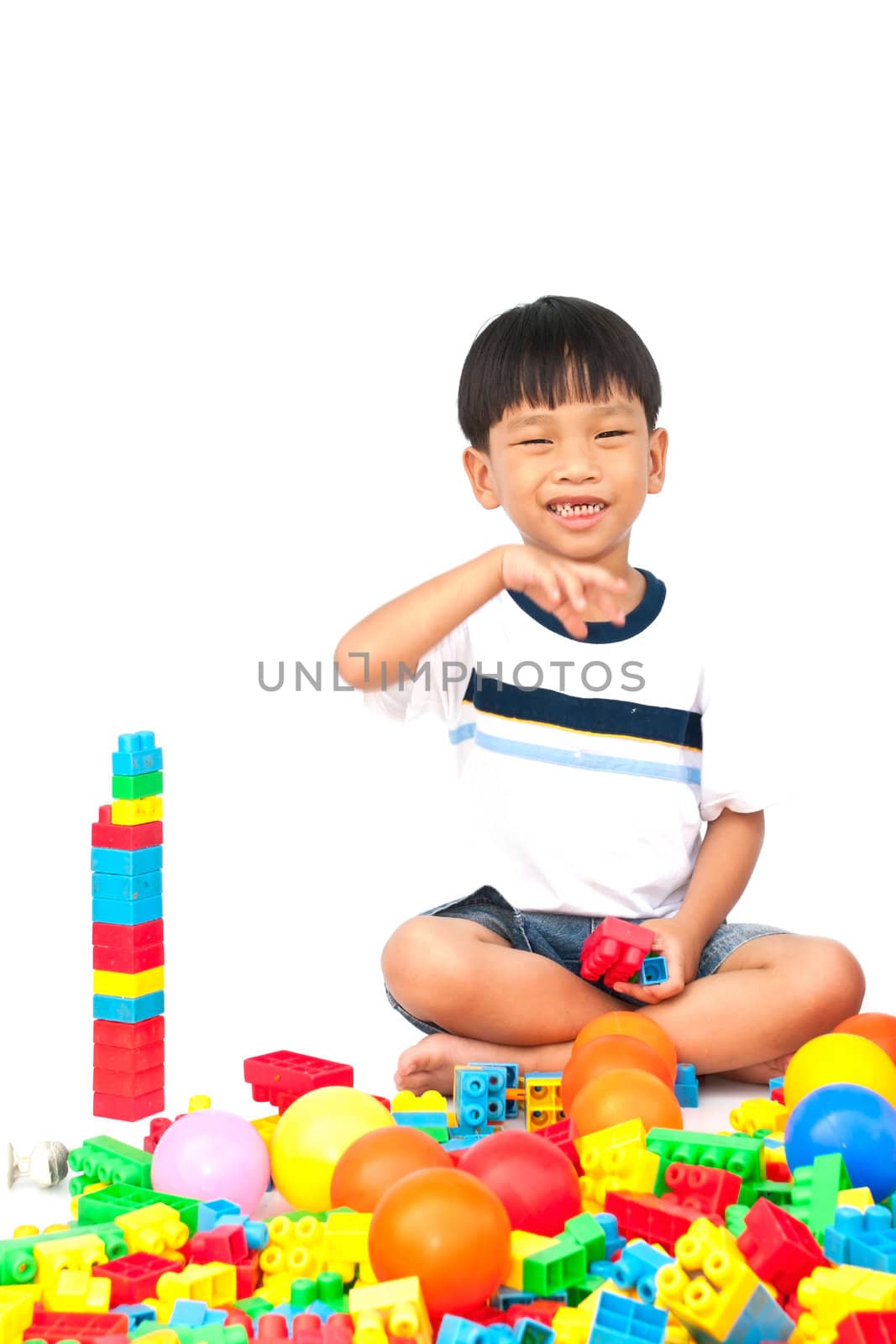 Little boy playing with toy on white background