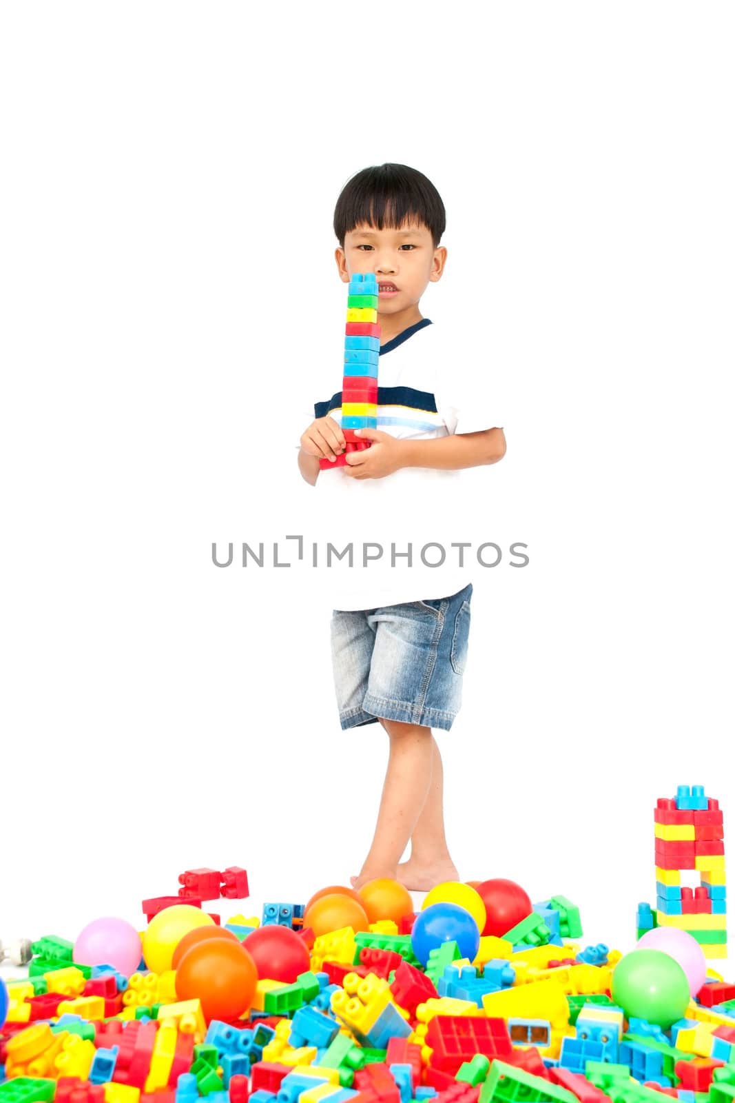 Little boy playing with toy on white background