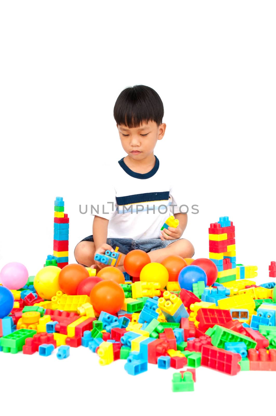 Little boy playing with toy on white background