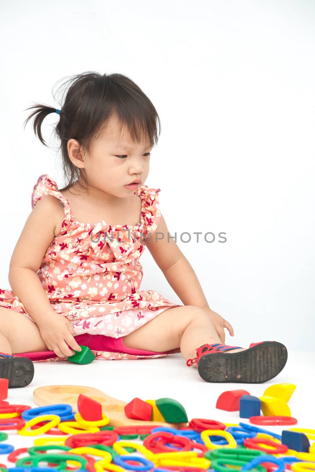 Little girl playing with toy on isolate background