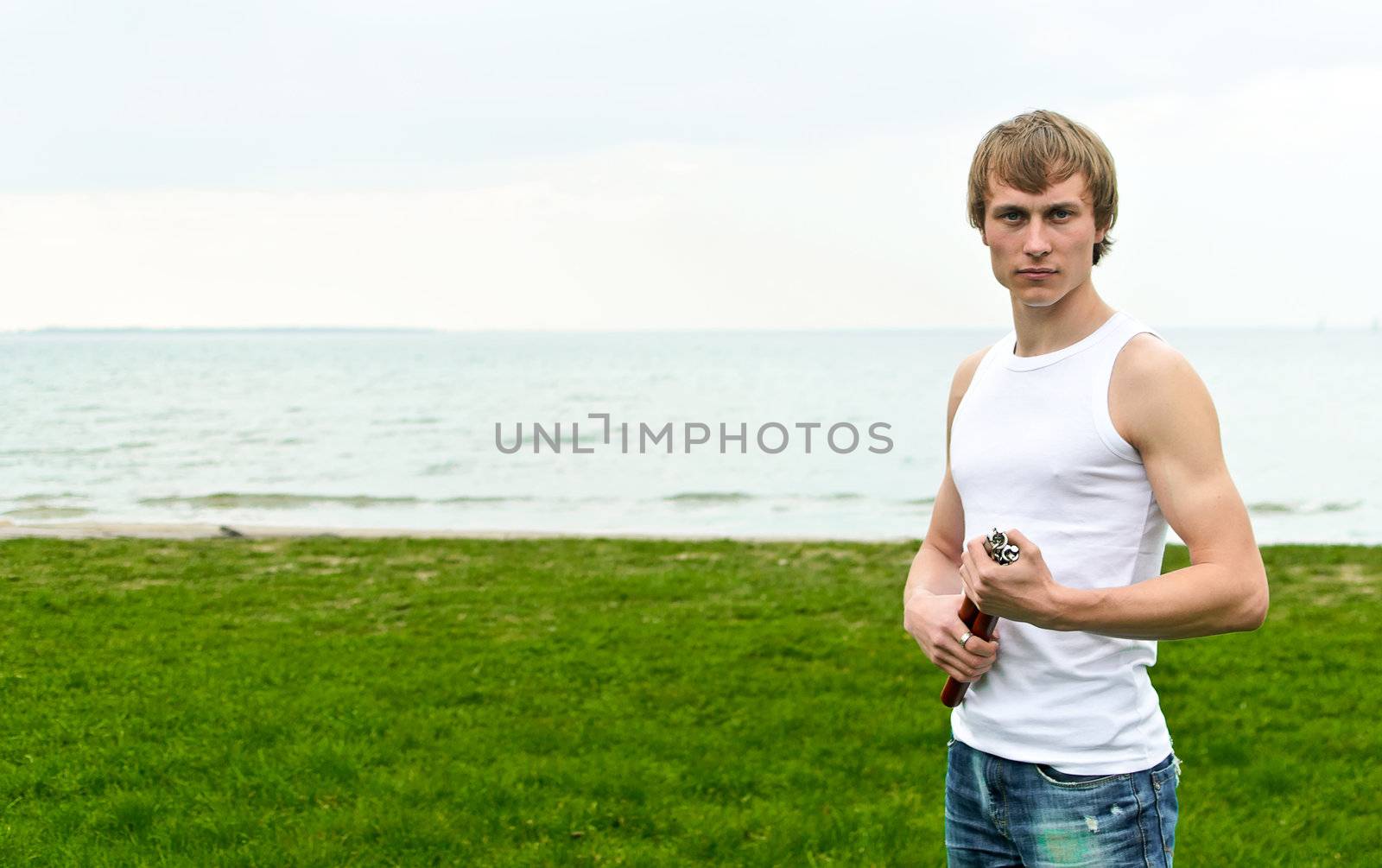 Martial arts: Man with nunchaku. Place for text.