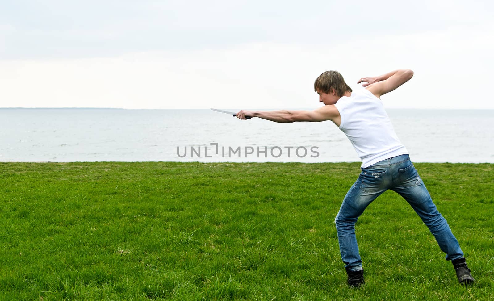 Man with military knife  by the seaside