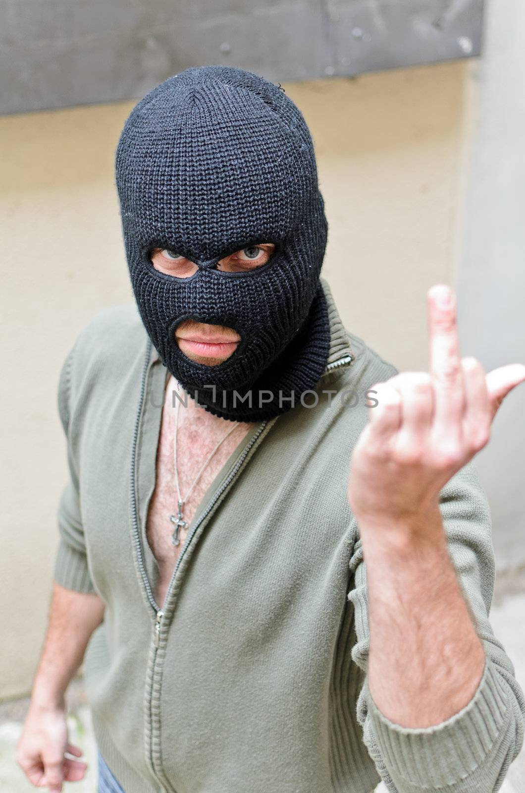 Burglar wearing a mask shows fuck gesture.