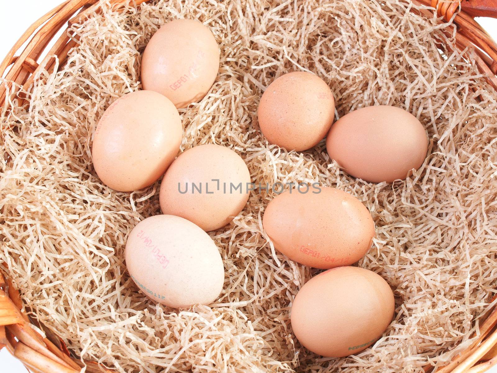 Eggs in a wicker basket with straw