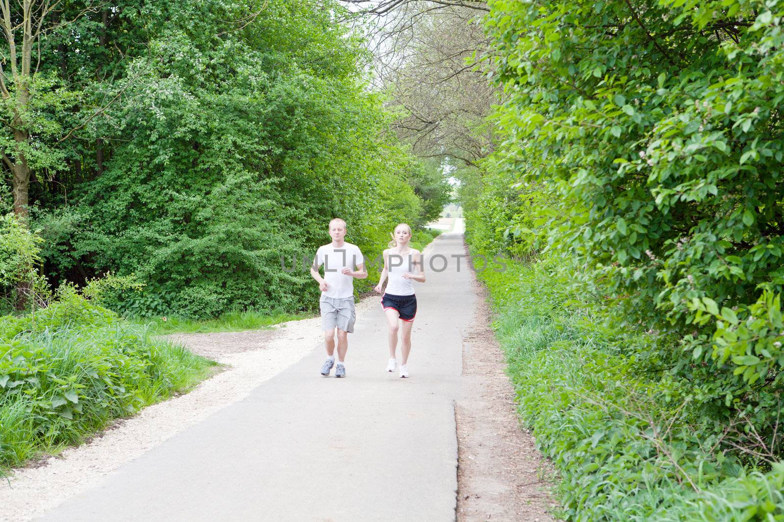 young couple is jogging in the forest by juniart