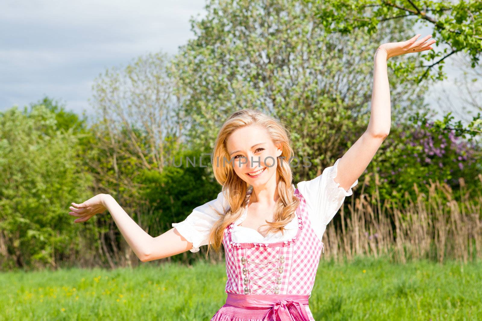 young woman with pink dirndl outdoor in summer