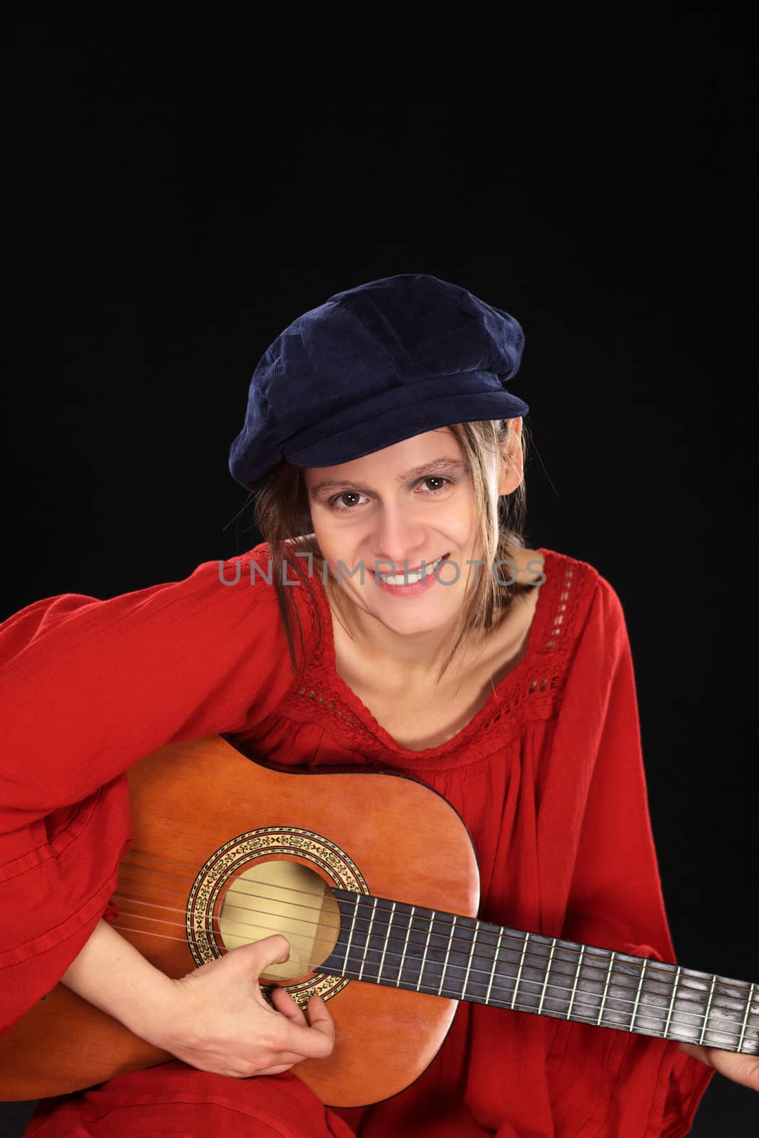 Young beautiful Caucasian woman playing the guitar (Selective Focus, Focus on the face)
