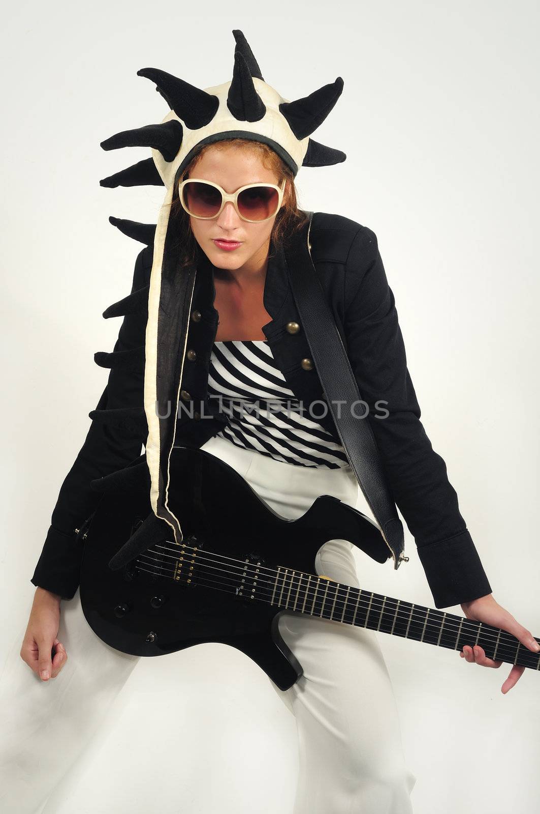 Portrait of young funky girl playing electric guitar isolated on white
