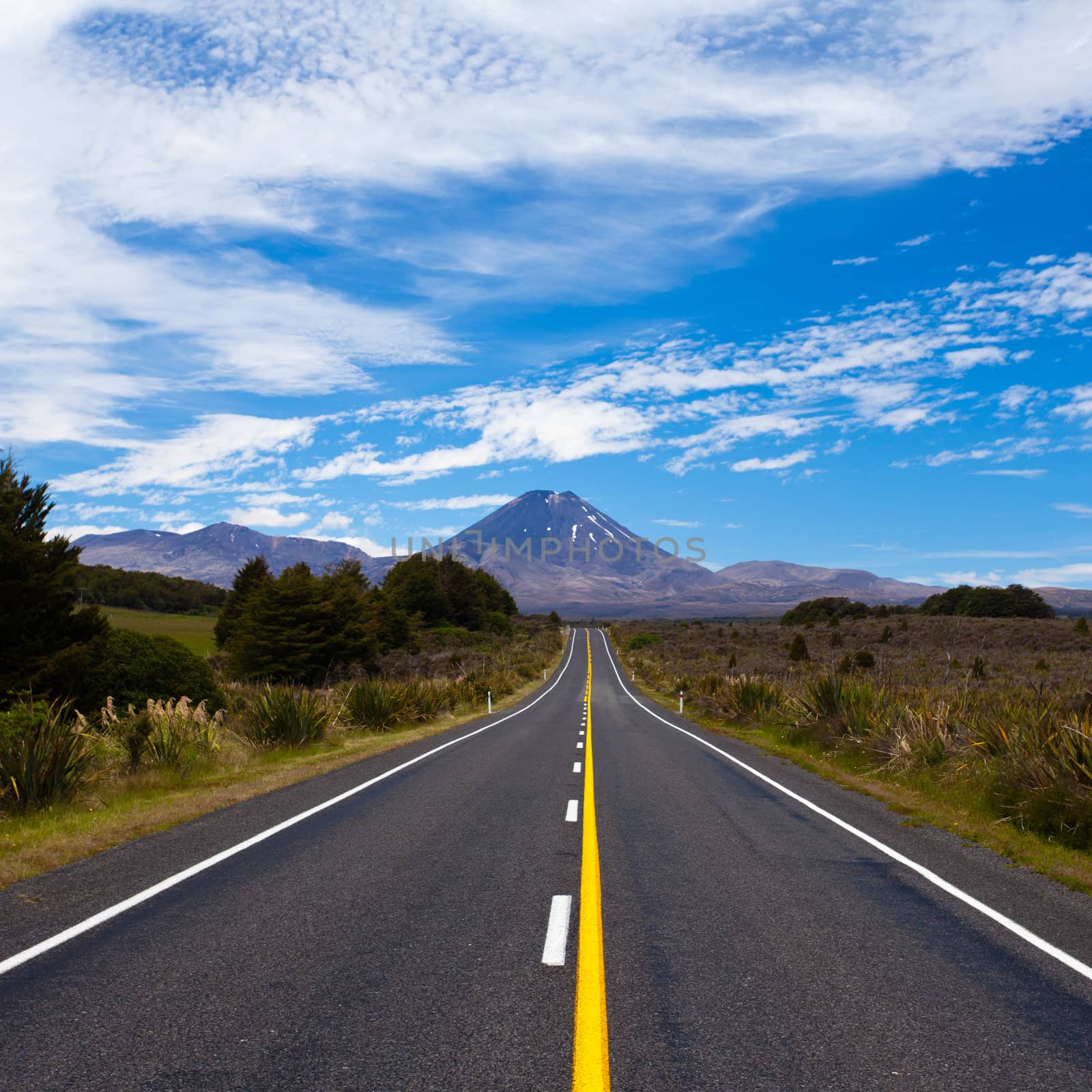 Straight highway leading to active volcano cone of Mount Ngauruhoe in Tongariro National Park, North Island of New Zealand