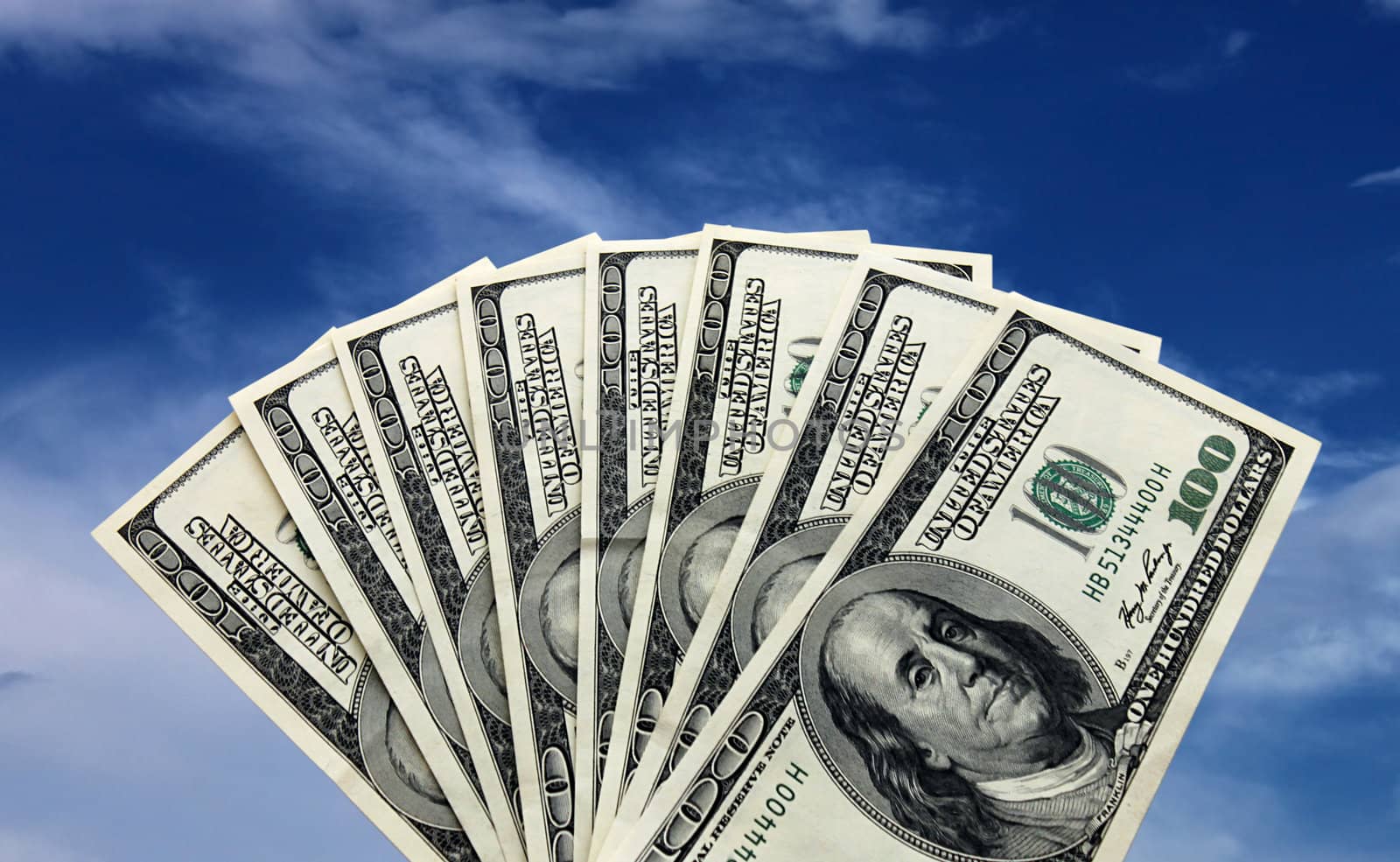 fan-shaped dollars over blue sky