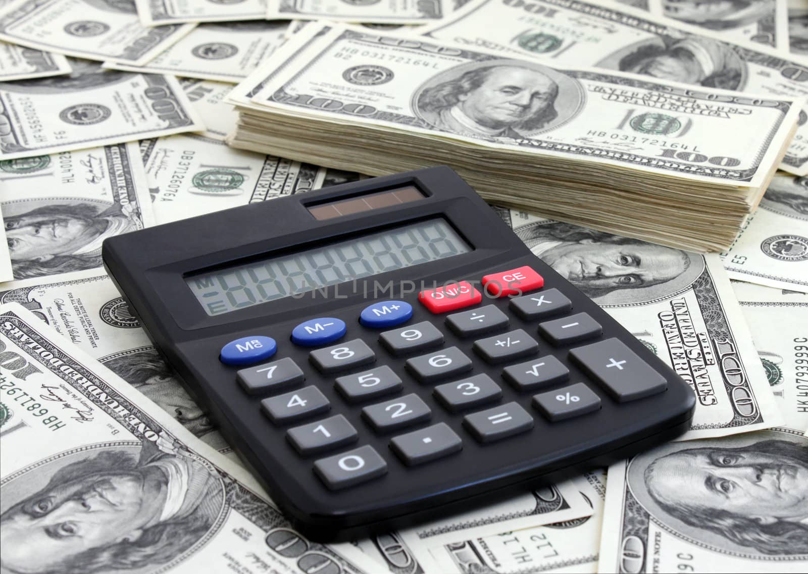 calculating income: calculator near a pile of dollars