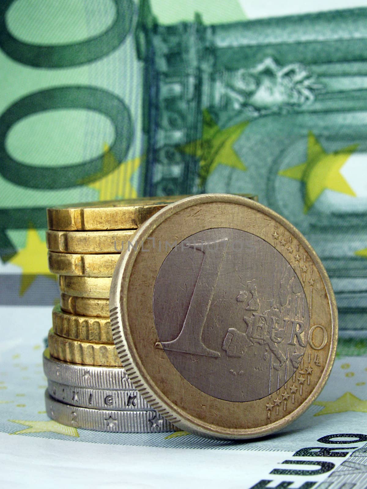 one euro with other coins on 100 euro banknote