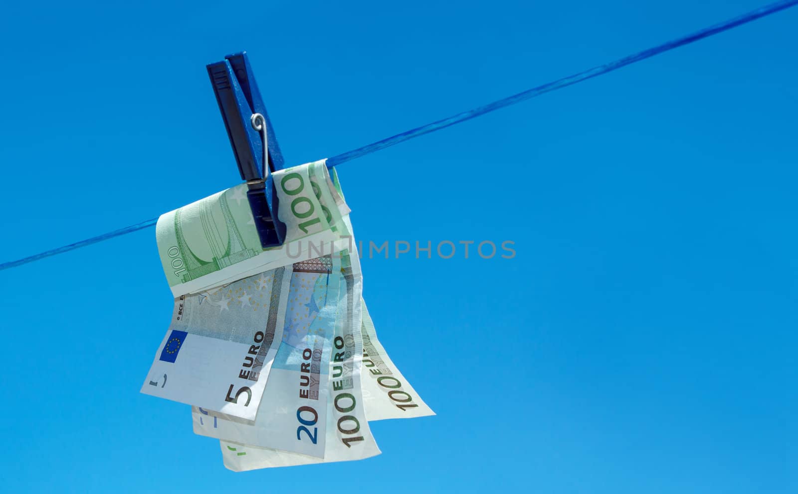 concept of  money hanging on clothesline against blue sky