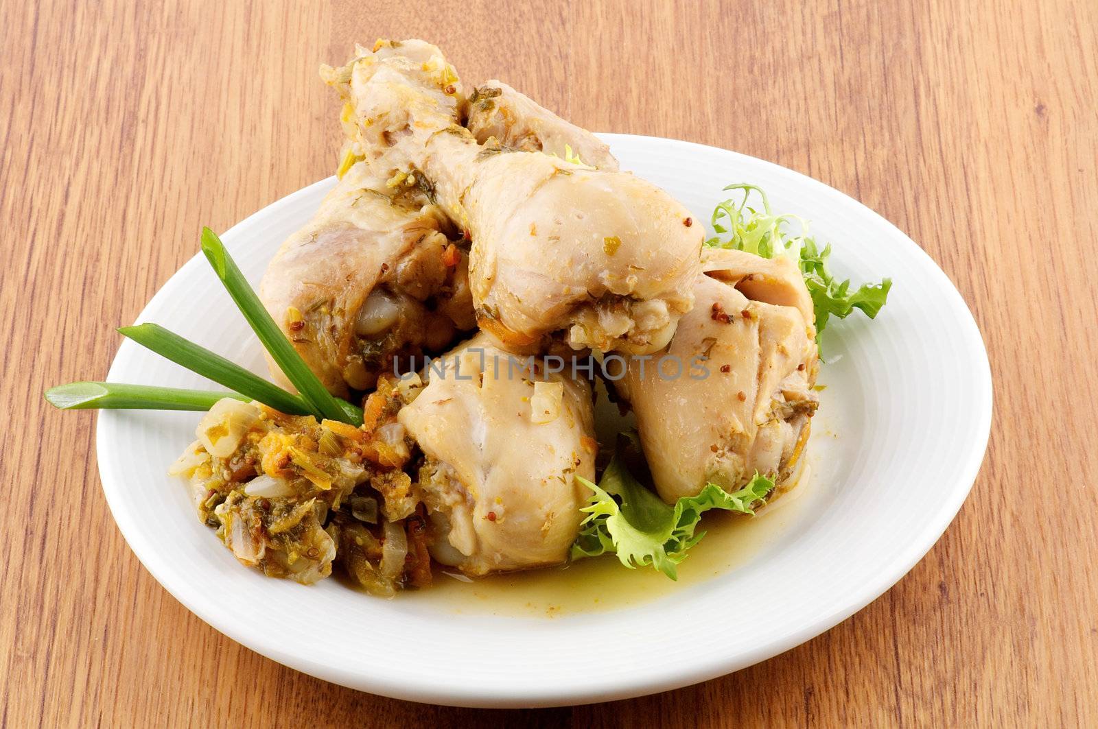 Roasted chicken legs vegetables saute and greens close up on wooden background