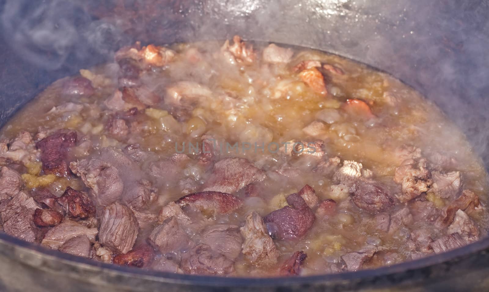 meat for pilaf prepares in a big cauldron