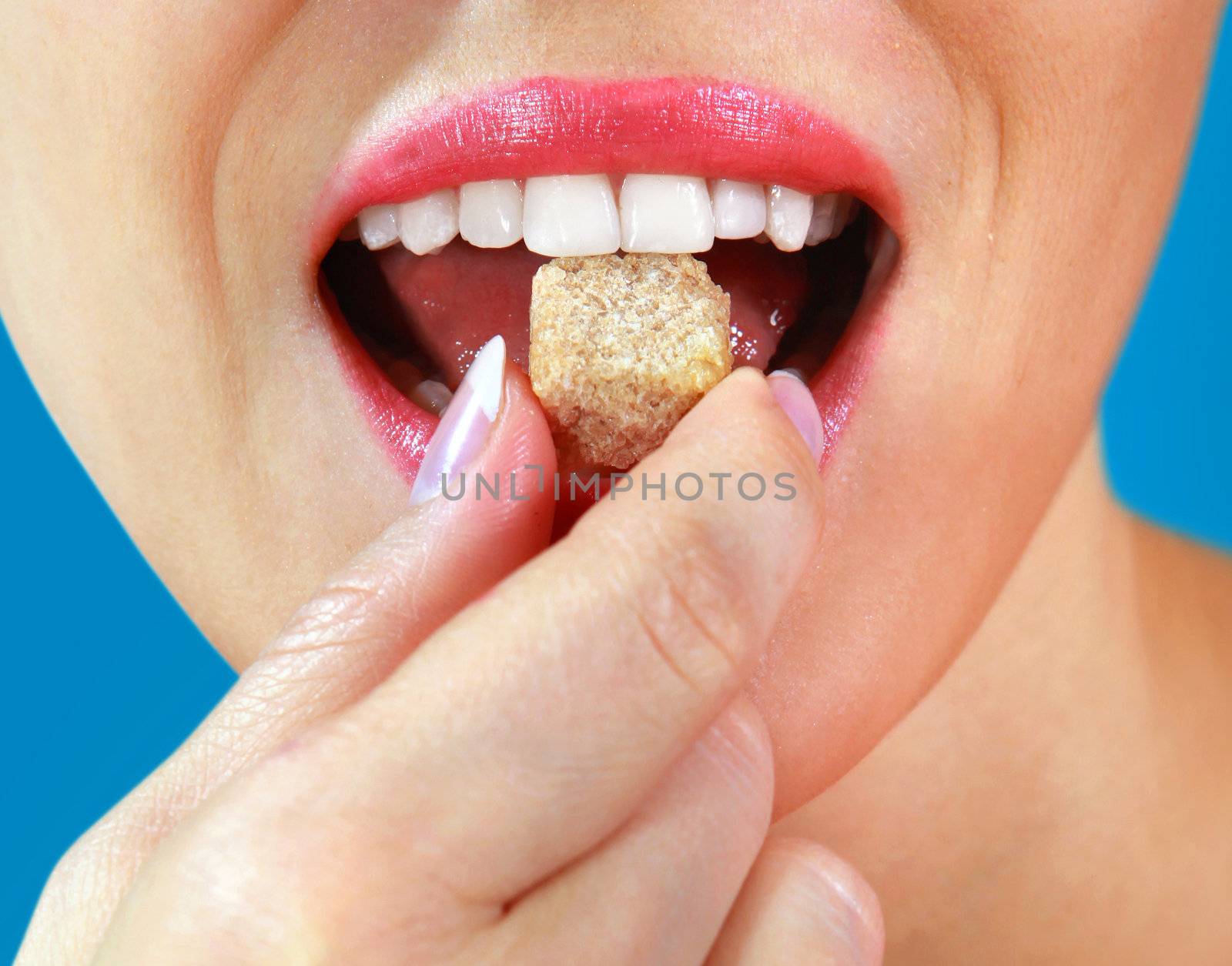 part of beautiful girl eats piece of sweets