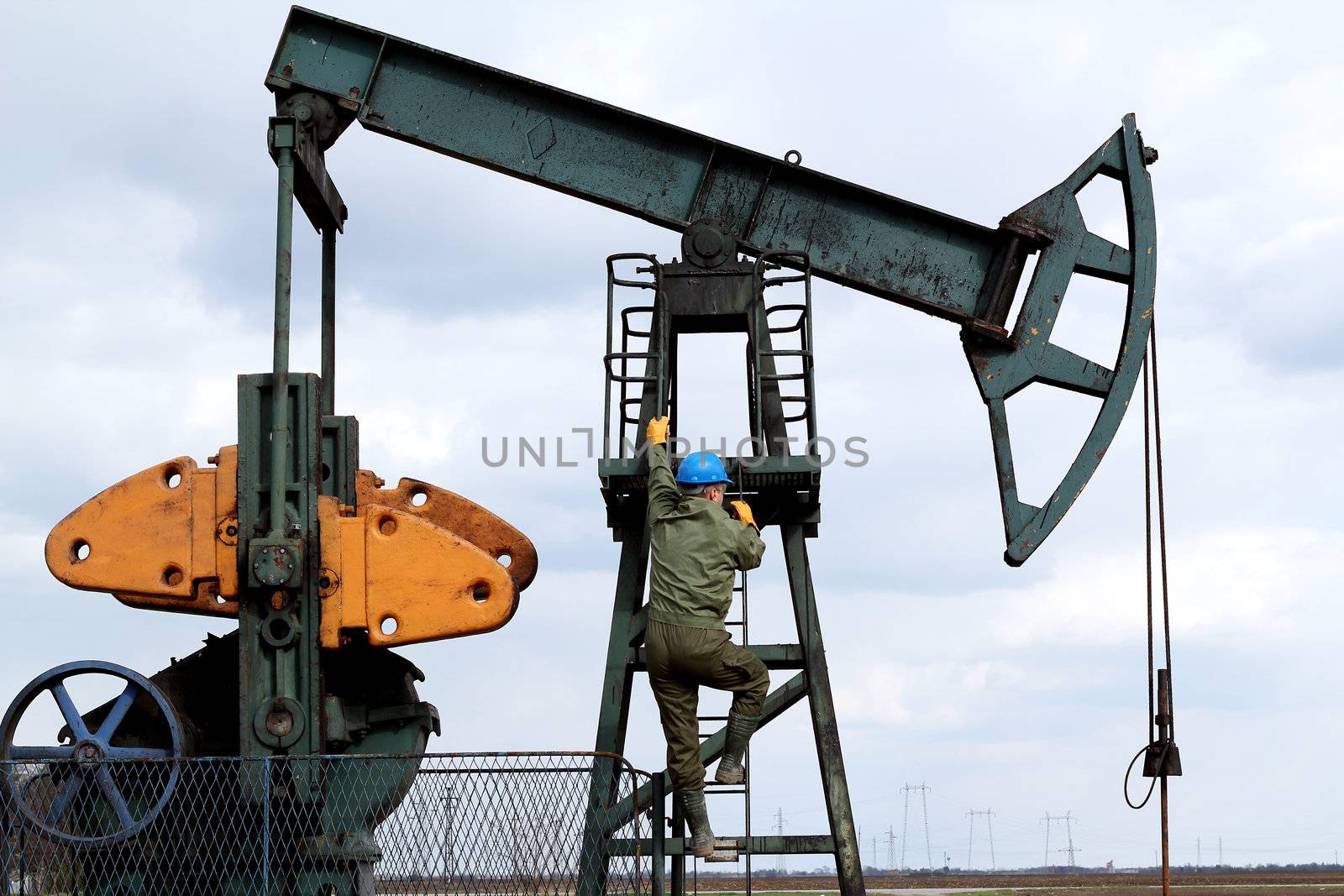 oil worker climbs to the pumpjack