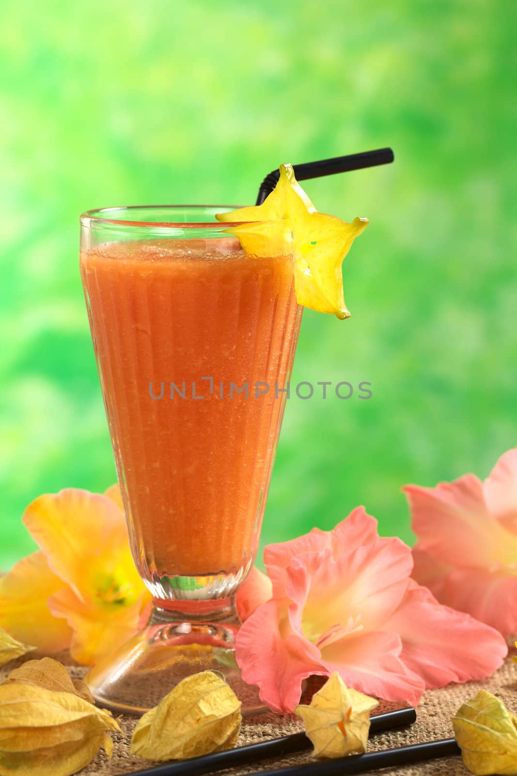 Fresh papaya juice garnished with a carambola slice (Selective Focus, Focus on the carambola and the upper part of the glass)