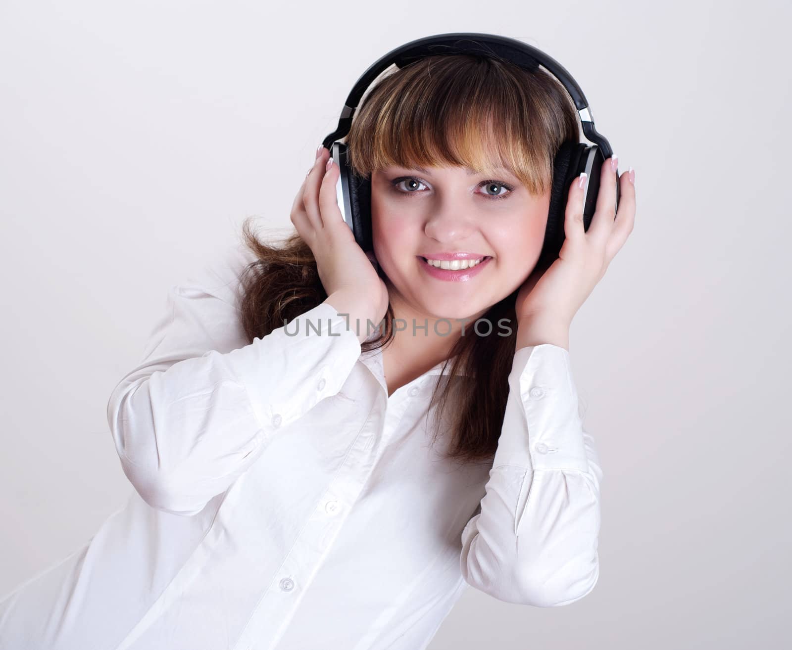 portrait of a beautiful woman in a white blouse, listening to music and happy