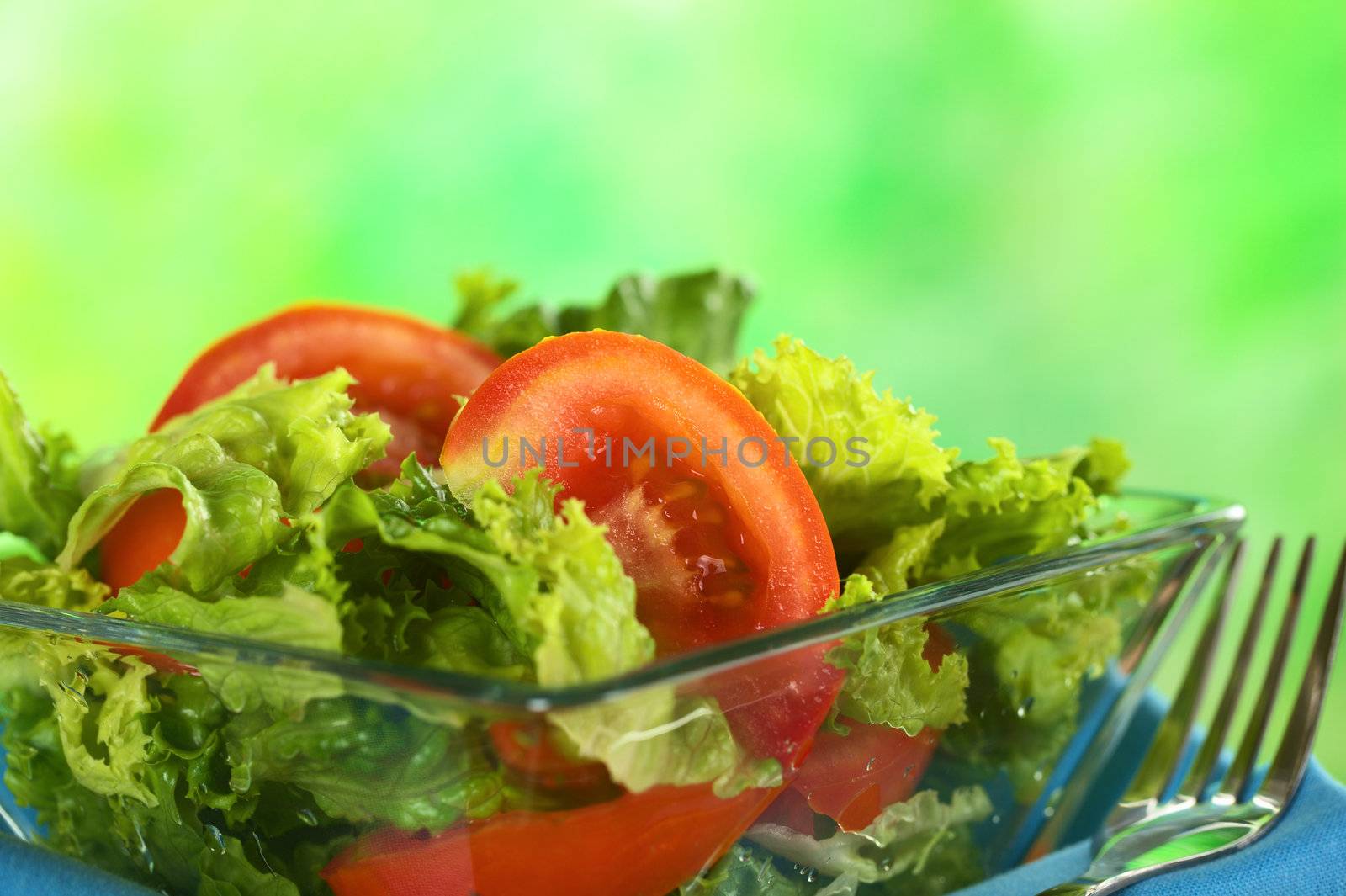 Fresh salad of lettuce and tomato (Selective Focus, Focus on the tomato slice in the middle of the photo) 