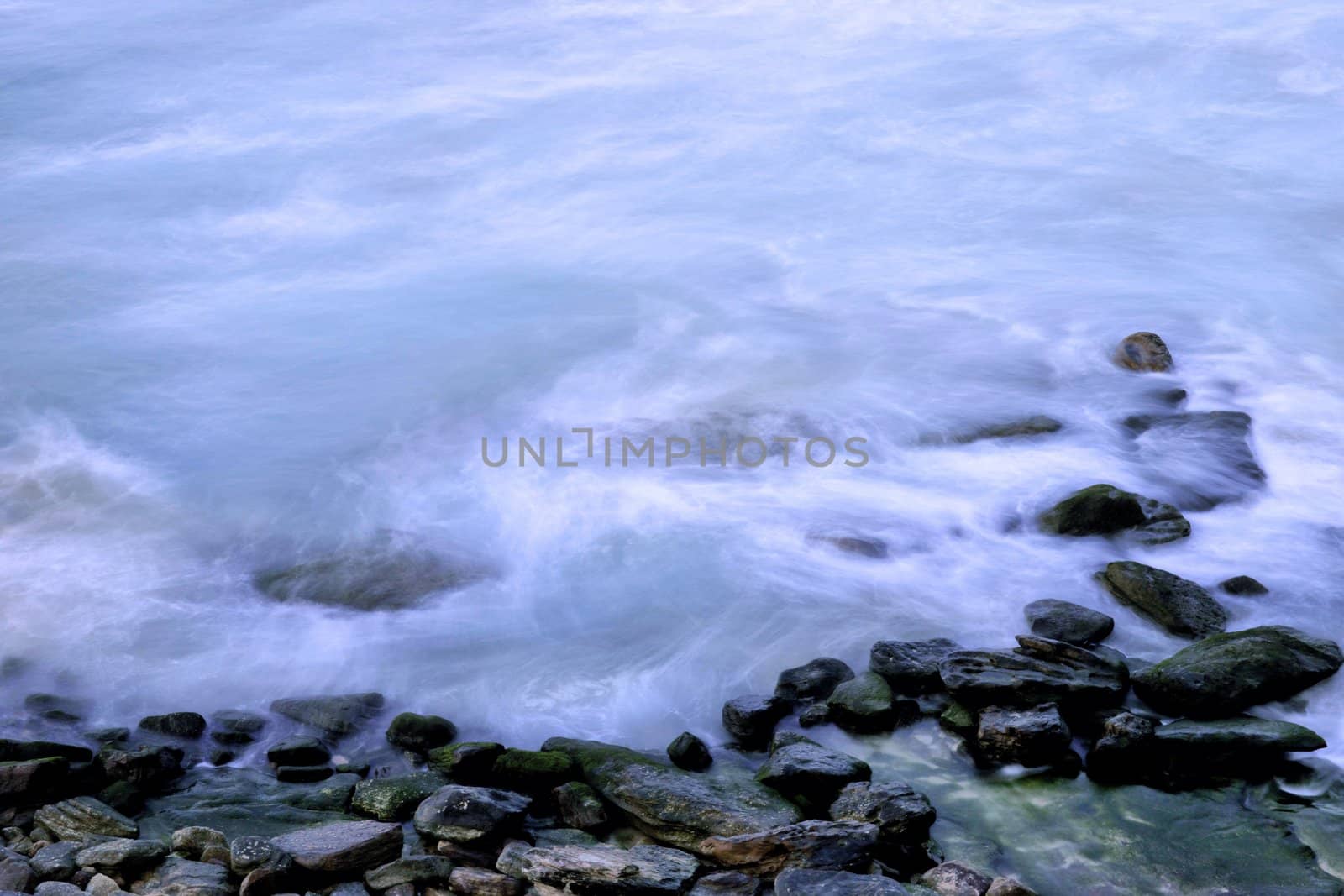 ocean waves gently come over these rocks