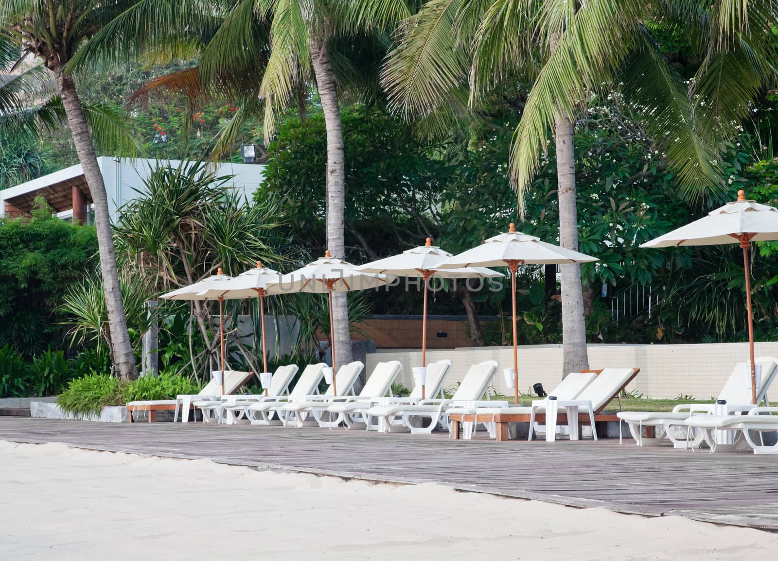 Beach chair and umbrella on tropical sand beach by FrameAngel